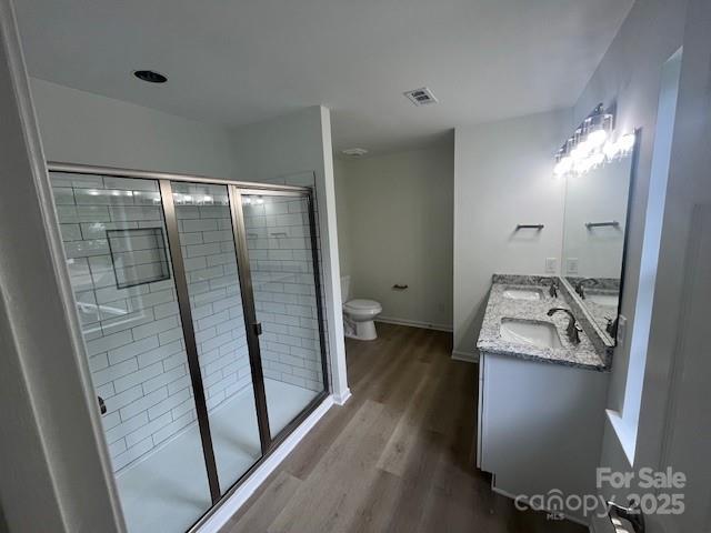 11021 Scrimshaw Ln, Charlotte, NC 28215 - full bath with wood finished floors, double vanity, and a stall shower
