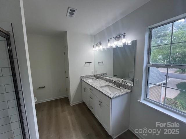 11021 Scrimshaw Ln, Charlotte, NC 28215 - bathroom featuring wood finished floors, double vanity, and healthy amount of natural light