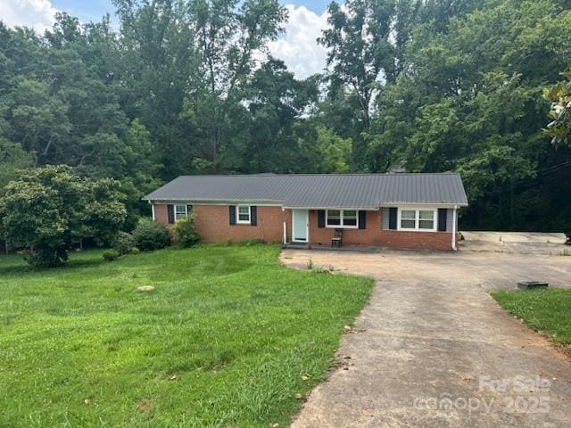 2116 Dana Pl, Shelby, NC 28152 - ranch-style home with concrete driveway, a front yard, a metal roof, brick siding, and a view of trees