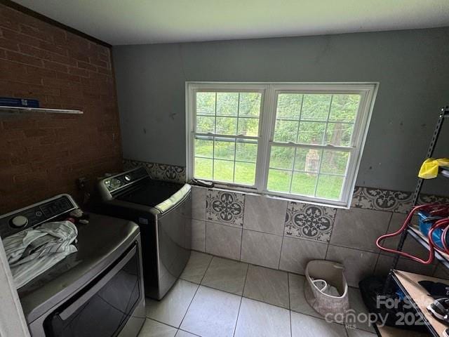 2116 Dana Pl, Shelby, NC 28152 - laundry room featuring washing machine and clothes dryer, light tile patterned floors, and tile walls