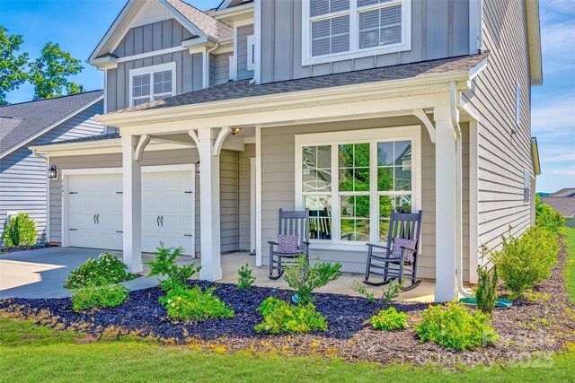 3041 Winged Teal Ct, Belmont, NC 28012 - view of front of property with board and batten siding, covered porch, driveway, and a shingled roof