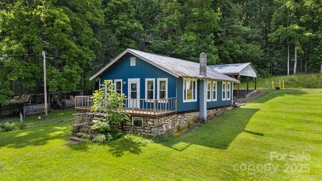 2428 Hamburg Rd, Mars Hill, NC 28754 - view of side of property featuring a metal roof, a yard, a wooded view, a deck, and a chimney