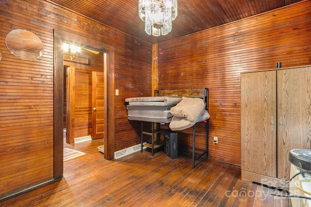 2428 Hamburg Rd, Mars Hill, NC 28754 - bedroom with hardwood / wood-style flooring, wooden walls, and a chandelier