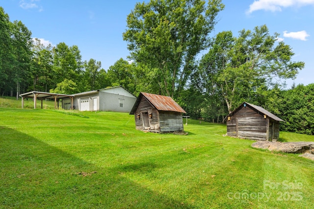 2428 Hamburg Rd, Mars Hill, NC 28754 - view of grassy yard featuring a garage, a storage shed, and view of wooded area