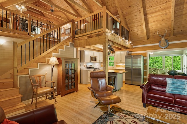 1980 Old Murray Rd, Mars Hill, NC 28754 - living room featuring a wood ceiling with exposed beams, light wood-style floors, high vaulted ceiling, stairway, and wooden walls