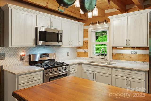 1980 Old Murray Rd, Mars Hill, NC 28754 - kitchen featuring stainless steel appliances, beam ceiling, decorative backsplash, light stone counters, and white cabinetry