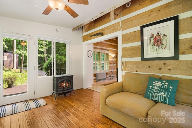 1980 Old Murray Rd, Mars Hill, NC 28754 - living room with wood walls, a wood stove, ceiling fan, and wood finished floors