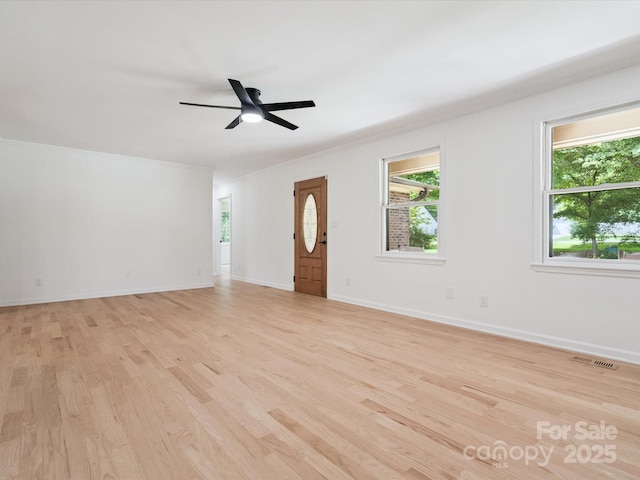 10728 Forest Dr, Matthews, NC 28105 - unfurnished living room with light wood-style flooring, plenty of natural light, and ceiling fan