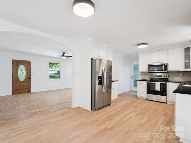 10728 Forest Dr, Matthews, NC 28105 - kitchen with appliances with stainless steel finishes, dark countertops, white cabinetry, backsplash, and ornamental molding