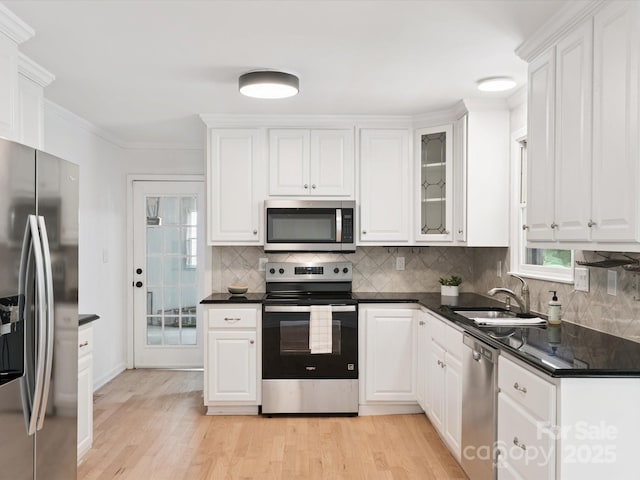 10728 Forest Dr, Matthews, NC 28105 - kitchen with stainless steel appliances, white cabinetry, backsplash, light wood-style flooring, and ornamental molding