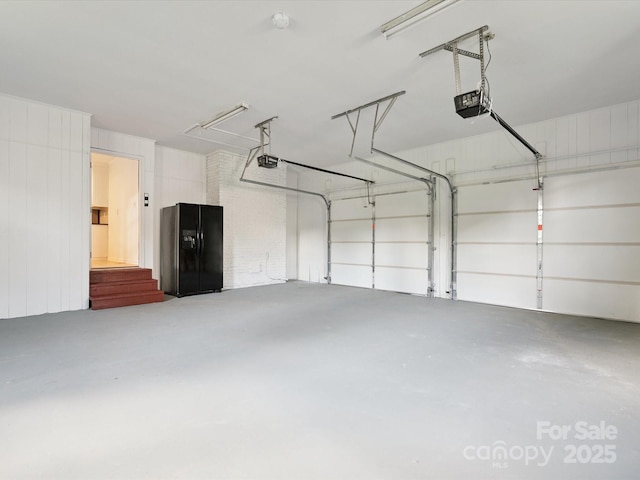 10728 Forest Dr, Matthews, NC 28105 - garage featuring black refrigerator with ice dispenser and a garage door opener