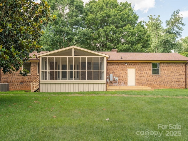 10728 Forest Dr, Matthews, NC 28105 - rear view of house featuring a sunroom, brick siding, a lawn, and a chimney