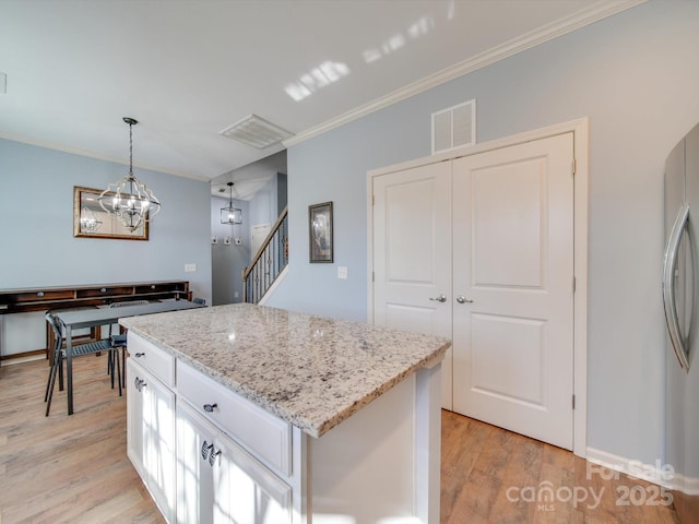 120 Prairie View Ct, Belmont, NC 28012 - kitchen with light wood-type flooring, crown molding, light stone counters, a center island, and pendant lighting