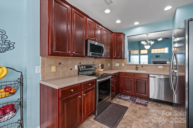 1498 Burrell Ave NW, Concord, NC 28027 - kitchen with stainless steel appliances, dark brown cabinets, light countertops, tasteful backsplash, and recessed lighting