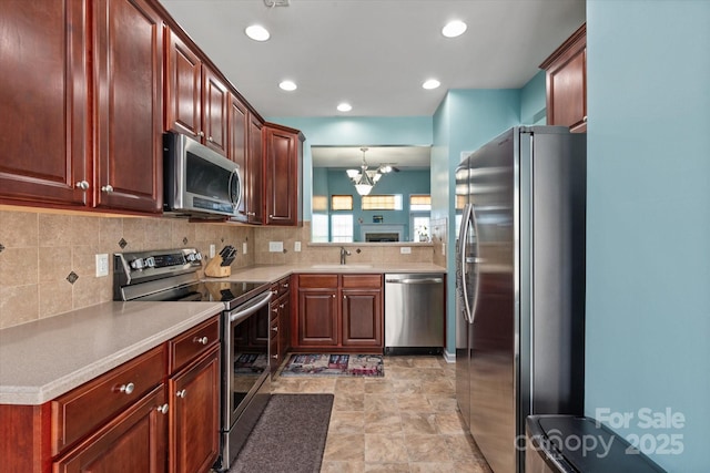 1498 Burrell Ave NW, Concord, NC 28027 - kitchen featuring stainless steel appliances, tasteful backsplash, a chandelier, light countertops, and recessed lighting