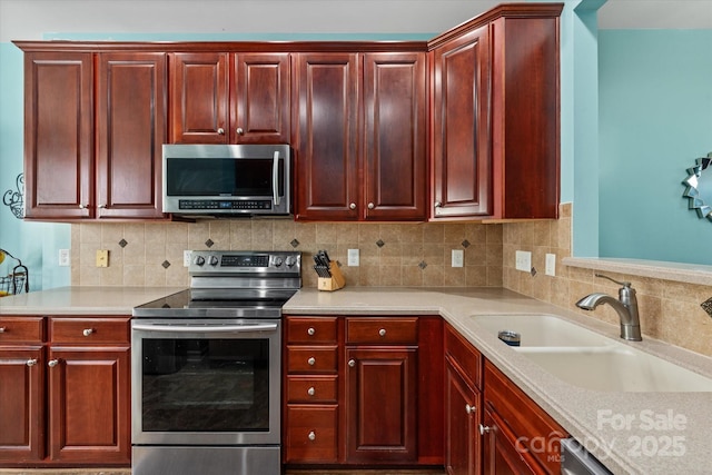 1498 Burrell Ave NW, Concord, NC 28027 - kitchen featuring stainless steel appliances, reddish brown cabinets, light countertops, and tasteful backsplash
