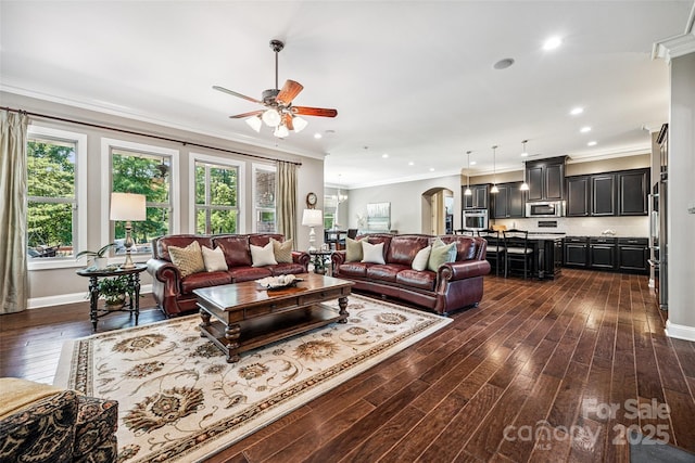 16547 Bastille Dr, Charlotte, NC 28278 - living room featuring a ceiling fan, dark wood-type flooring, ornamental molding, recessed lighting, and arched walkways