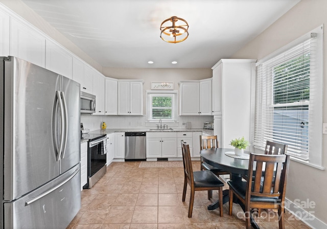 515 N Main Gq St, Granite Quarry, NC 28146 - kitchen with stainless steel appliances, light stone counters, white cabinetry, light tile patterned flooring, and recessed lighting