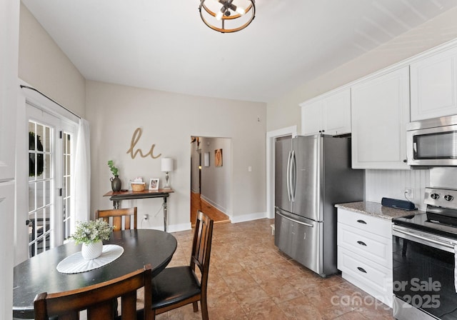515 N Main Gq St, Granite Quarry, NC 28146 - kitchen featuring appliances with stainless steel finishes, white cabinets, and light stone counters
