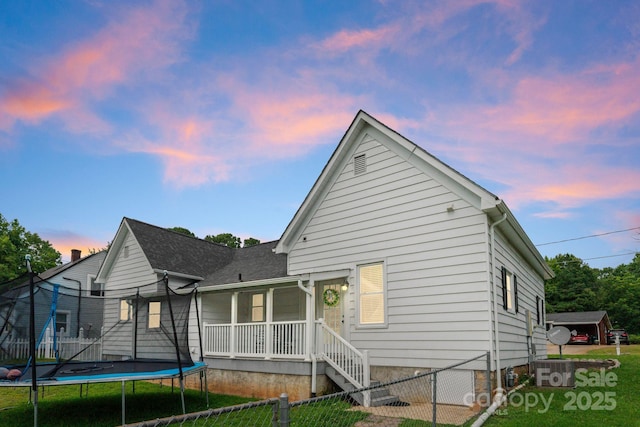 515 N Main Gq St, Granite Quarry, NC 28146 - back of house at dusk with a trampoline, a porch, and a gate
