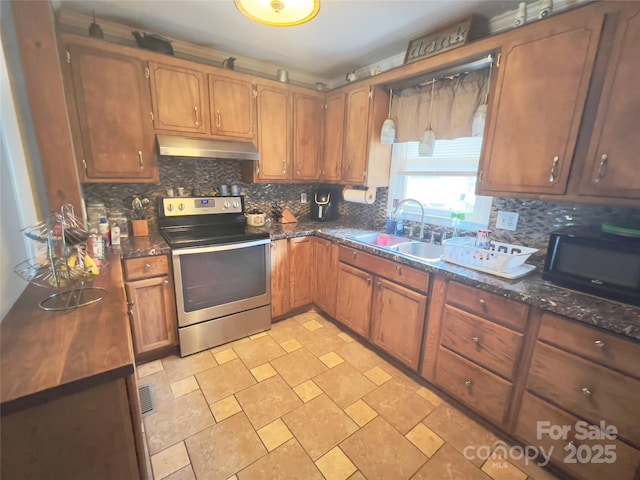 803 Bannon Pl, Lenoir, NC 28645 - kitchen with stainless steel range with electric cooktop, under cabinet range hood, black microwave, tasteful backsplash, and brown cabinets
