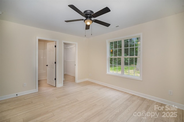 903 Brookdale St, Kannapolis, NC 28083 - unfurnished bedroom featuring light wood-style floors, a walk in closet, a closet, and a ceiling fan