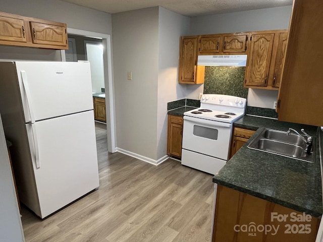 1714 Maribel Ave, Charlotte, NC 28216 - kitchen with white appliances, ventilation hood, dark countertops, light wood-type flooring, and brown cabinets