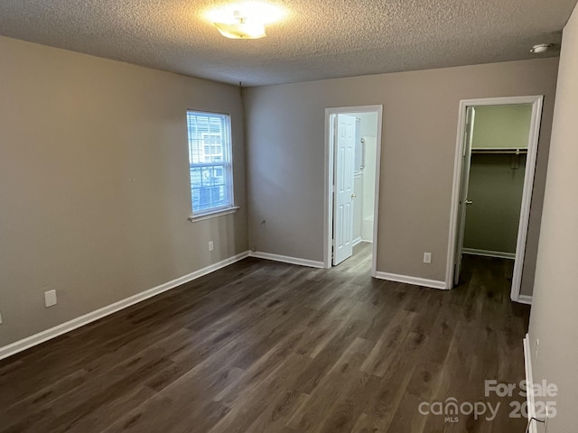 1714 Maribel Ave, Charlotte, NC 28216 - unfurnished bedroom with a textured ceiling, dark wood-style flooring, a spacious closet, a closet, and connected bathroom