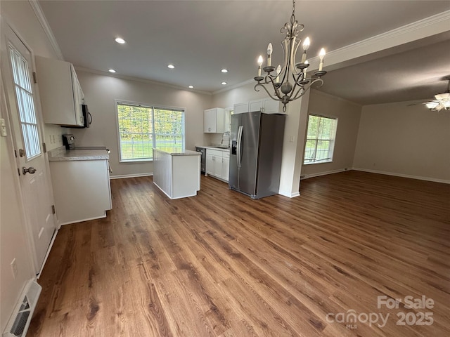 40287 Palmerville Rd, New London, NC 28127 - kitchen featuring stainless steel fridge, open floor plan, a center island, ornamental molding, and light countertops