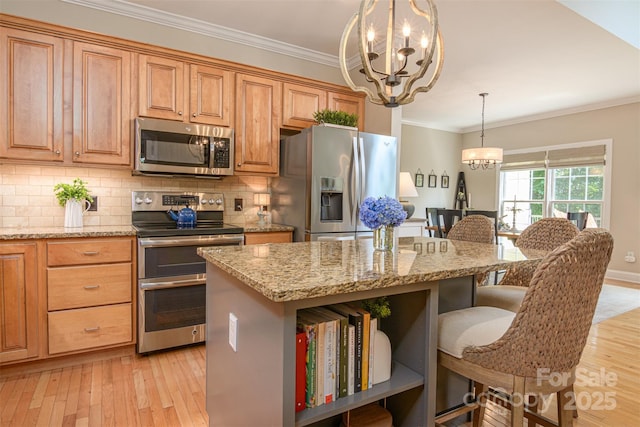 3 Chickadee Ln, Fairview, NC 28730 - kitchen with appliances with stainless steel finishes, a chandelier, a breakfast bar, ornamental molding, and light stone countertops
