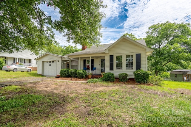 357 N Main St, Mount Pleasant, NC 28124 - ranch-style home featuring a porch, a garage, a chimney, and a front lawn