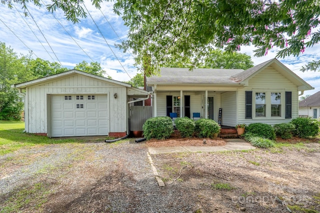 357 N Main St, Mount Pleasant, NC 28124 - ranch-style home featuring dirt driveway, a porch, an outdoor structure, an attached garage, and a shingled roof