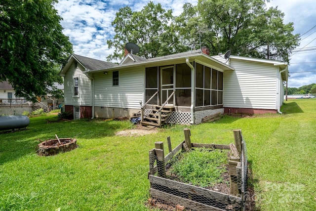357 N Main St, Mount Pleasant, NC 28124 - back of property featuring an outdoor fire pit, a vegetable garden, a sunroom, and a yard