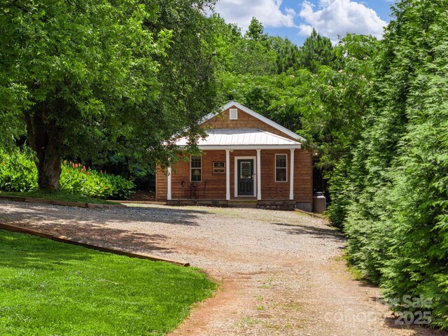 2784 Pea Ridge Rd, Mill Spring, NC 28756 - view of front of home featuring a porch, curved driveway, and a forest view