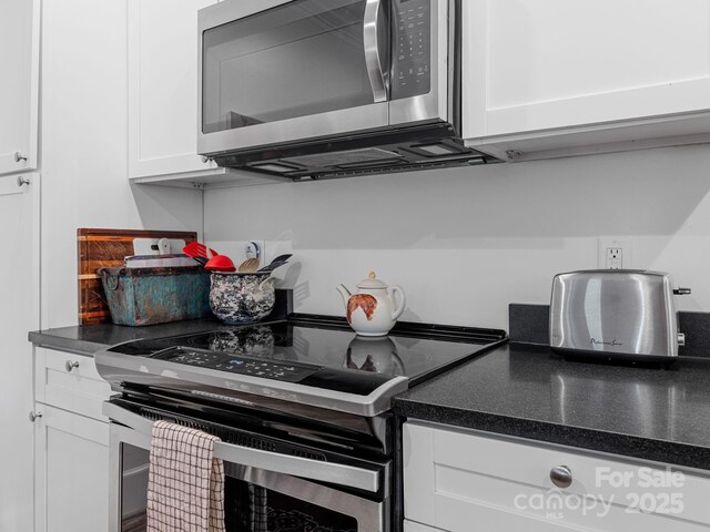 2784 Pea Ridge Rd, Mill Spring, NC 28756 - kitchen with appliances with stainless steel finishes, white cabinetry, and dark countertops
