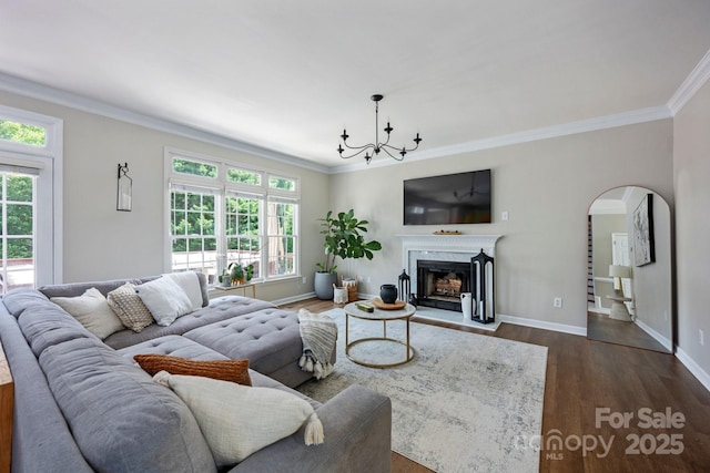 5005 Chestnut Knoll Ln, Charlotte, NC 28269 - living room featuring plenty of natural light, crown molding, a chandelier, dark wood-type flooring, and arched walkways
