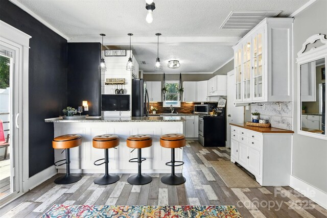 840 10th Street Blvd NW, Hickory, NC 28601 - kitchen with a peninsula, stainless steel appliances, a textured ceiling, decorative backsplash, and glass insert cabinets