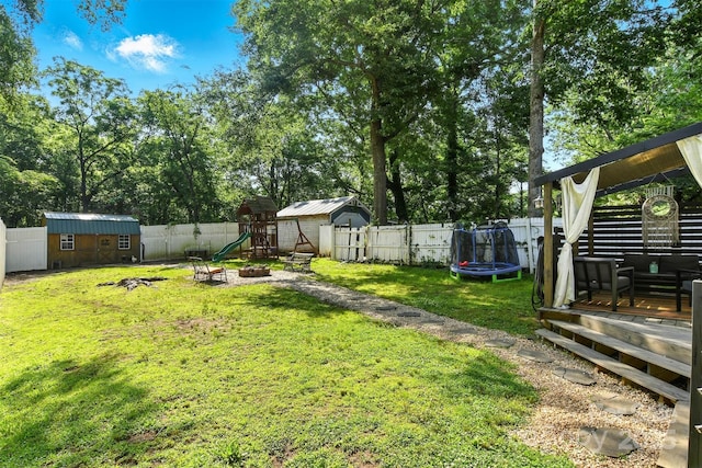 840 10th Street Blvd NW, Hickory, NC 28601 - fenced backyard with a storage unit, a trampoline, a playground, a fire pit, and view of scattered trees