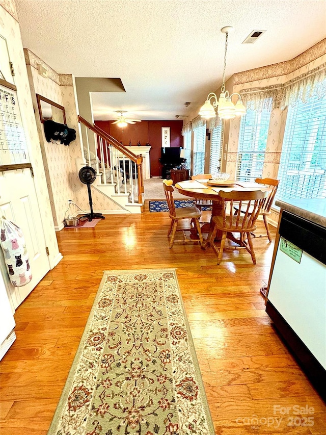 1902 Stonewyck Ave, Kannapolis, NC 28081 - dining space with wallpapered walls, stairs, a textured ceiling, a chandelier, and light wood-style floors