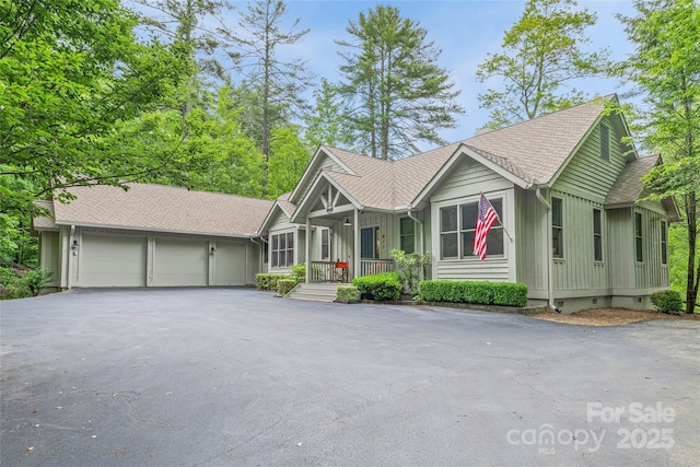 877 Winding Creek Rd, Sapphire, NC 28774 - ranch-style home featuring a garage, driveway, a porch, board and batten siding, and roof with shingles