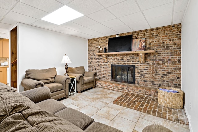 233 Church St, Ellenboro, NC 28040 - living room featuring a fireplace, a paneled ceiling, light tile patterned floors, and brick wall