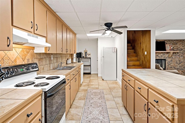 233 Church St, Ellenboro, NC 28040 - kitchen with electric stove, under cabinet range hood, freestanding refrigerator, tile countertops, and backsplash