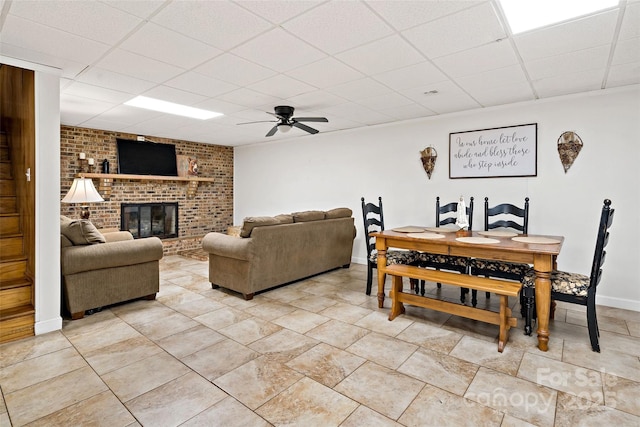 233 Church St, Ellenboro, NC 28040 - dining space with a drop ceiling, ceiling fan, light tile patterned floors, and a brick fireplace