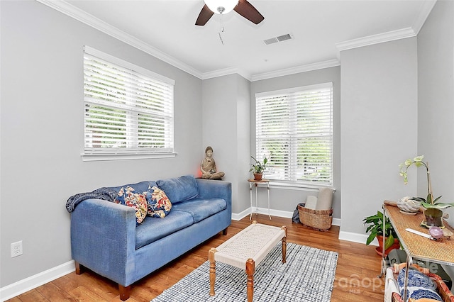 921 NE Dr, Davidson, NC 28036 - living area with healthy amount of natural light, wood finished floors, crown molding, and a ceiling fan