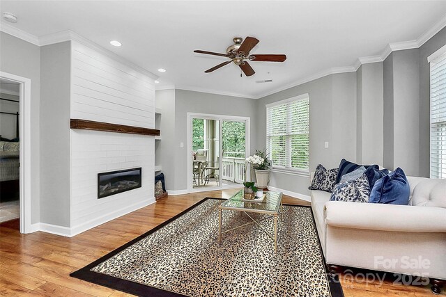921 NE Dr, Davidson, NC 28036 - living area with wood finished floors, a ceiling fan, a fireplace, crown molding, and recessed lighting