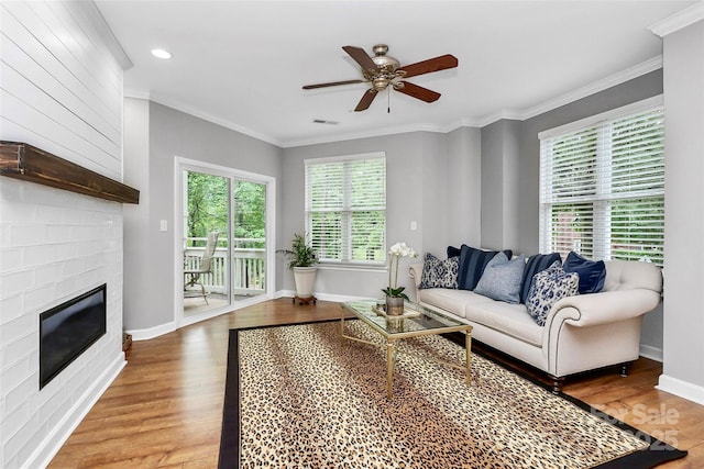 921 NE Dr, Davidson, NC 28036 - living room with a ceiling fan, wood finished floors, crown molding, a large fireplace, and recessed lighting