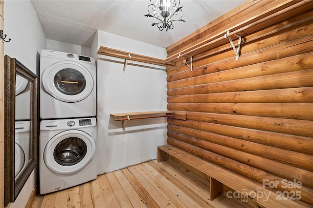 6836 Summer Hill Dr, Denver, NC 28037 - laundry room featuring stacked washing machine and dryer, rustic walls, and light wood-type flooring