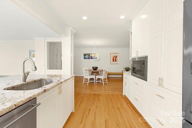 4526 Longwood Dr, Charlotte, NC 28209 - kitchen with stainless steel appliances, white cabinets, light wood-style flooring, crown molding, and pendant lighting