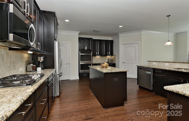 3913 Widgeon Way, Waxhaw, NC 28173 - kitchen featuring appliances with stainless steel finishes, crown molding, tasteful backsplash, light stone counters, and a center island