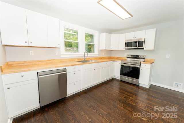 1208 Martin Luther King Ave, Kannapolis, NC 28083 - kitchen with appliances with stainless steel finishes, wooden counters, dark wood-style flooring, and white cabinetry